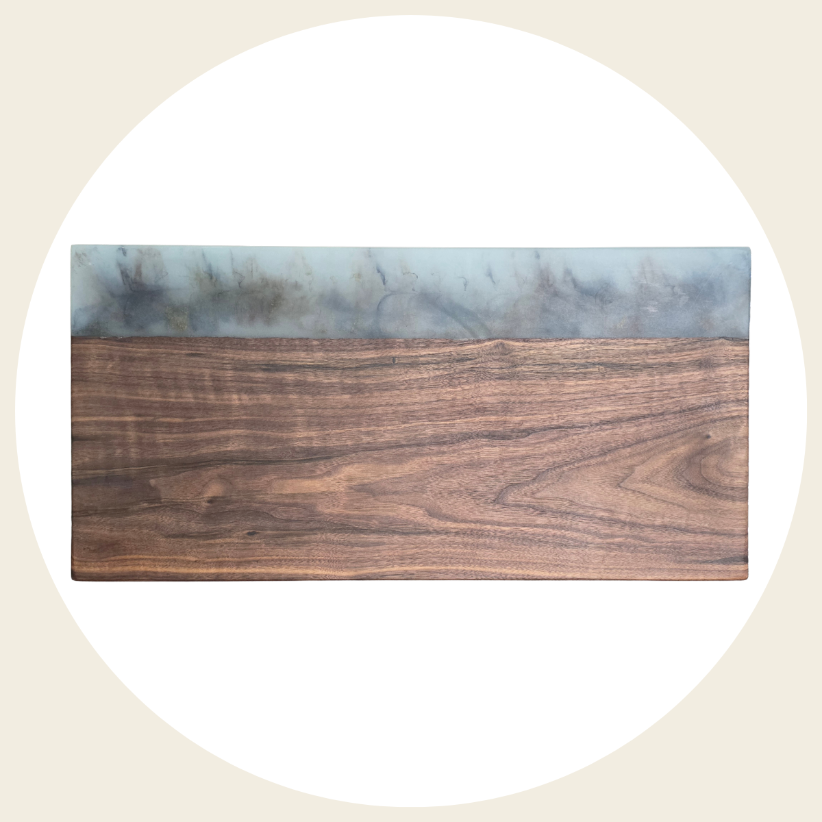 Handcrafted wood and resin cutting board with blue and gold accents, styled on a kitchen counter with a potted plant.