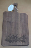 Front of walnut-finished acacia serving board engraved with a cardinal, berries and evergreen branches