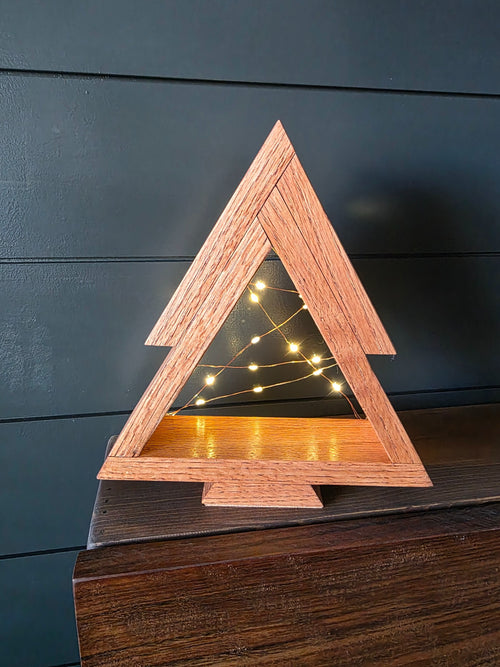 Reverse view of chestnut-stained white oak tabletop Christmas tree with warm fairy lights