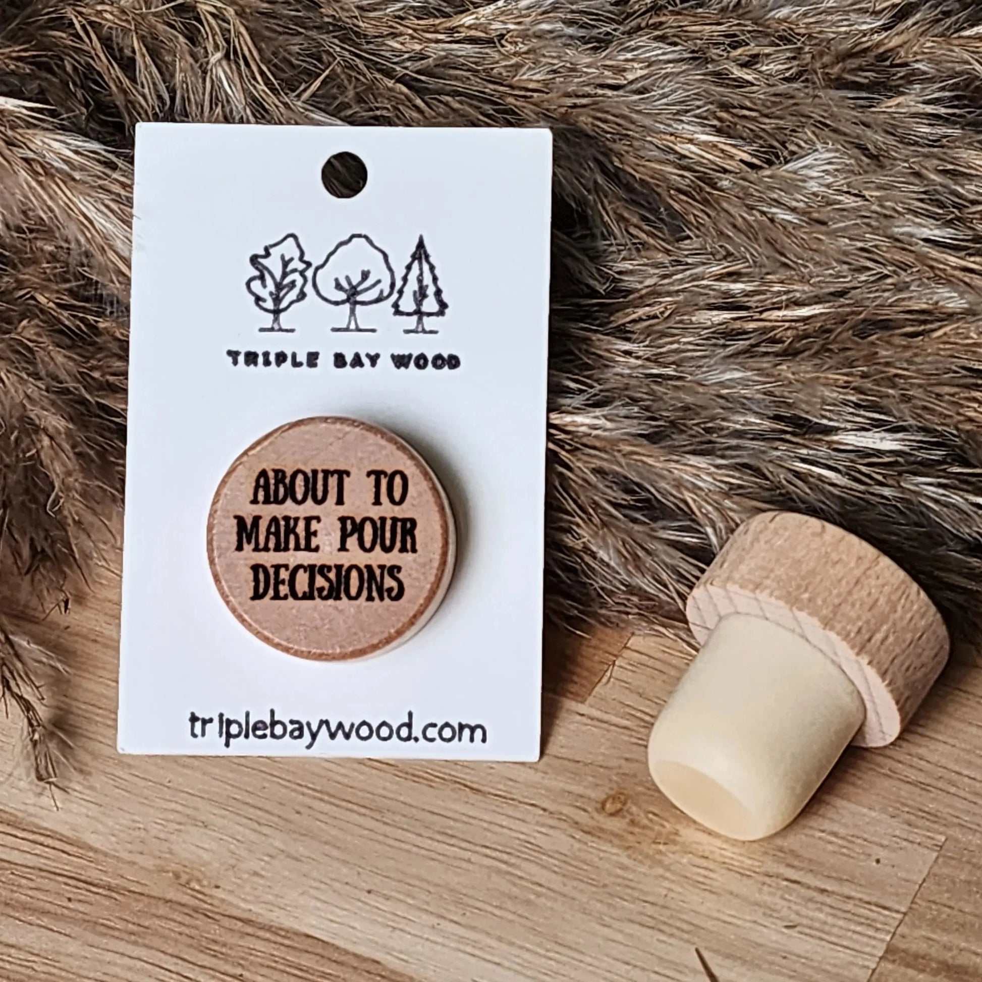 Wood wine stopper with 'About to make pour decisions' text on rustic background