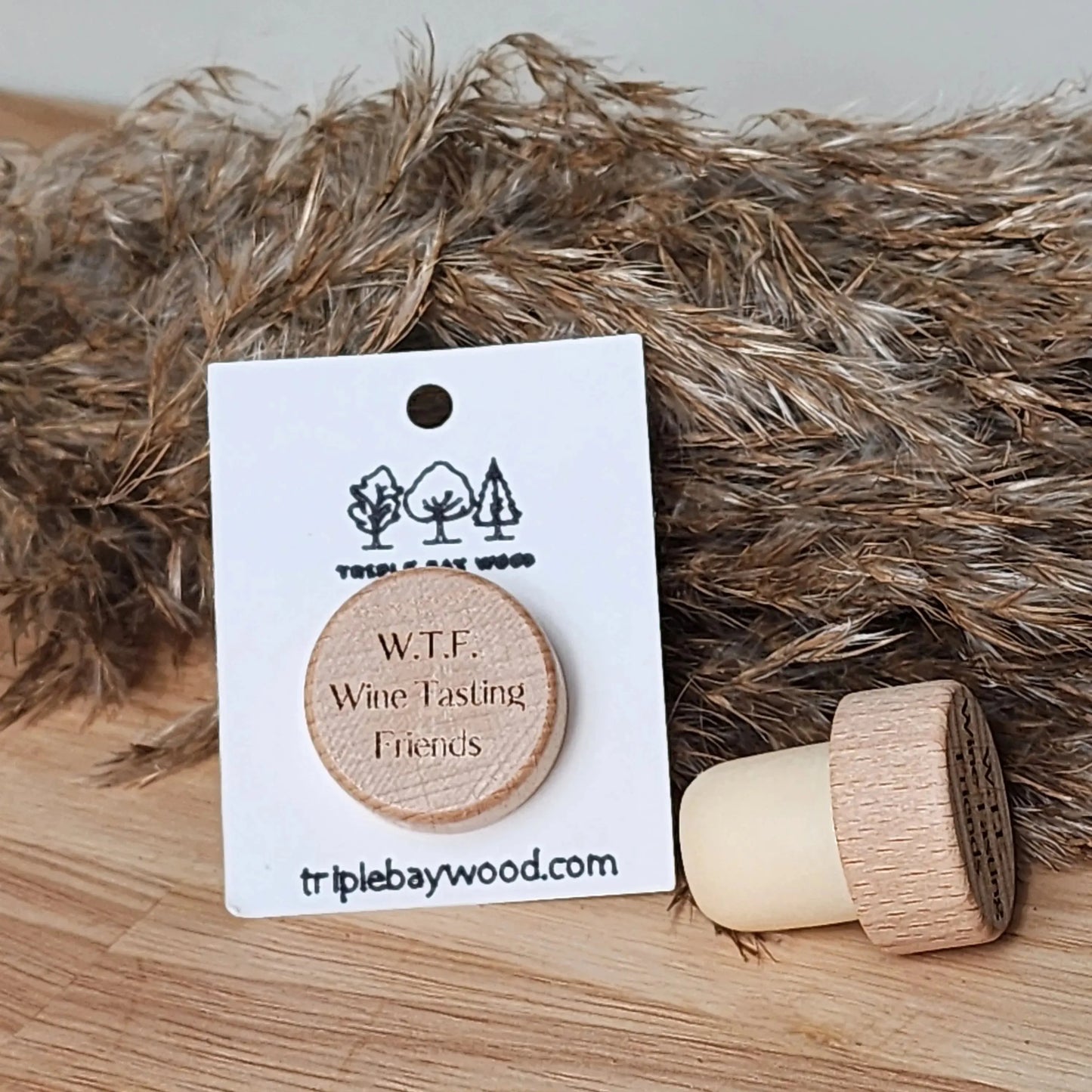 Wooden wine cork engraved with W.T.F. Wine Tasting Friends, on natural background.