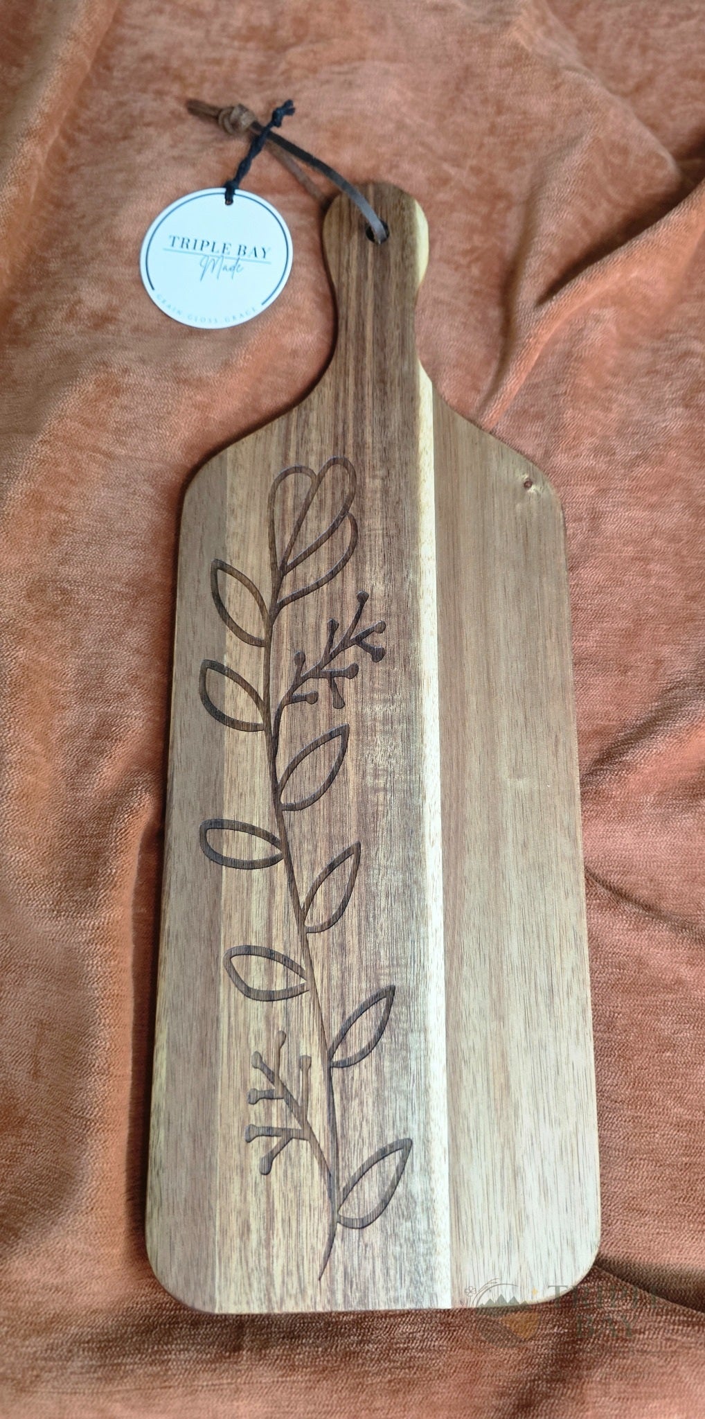 Engraved botanical acacia paddle serving board with leather hanging loop