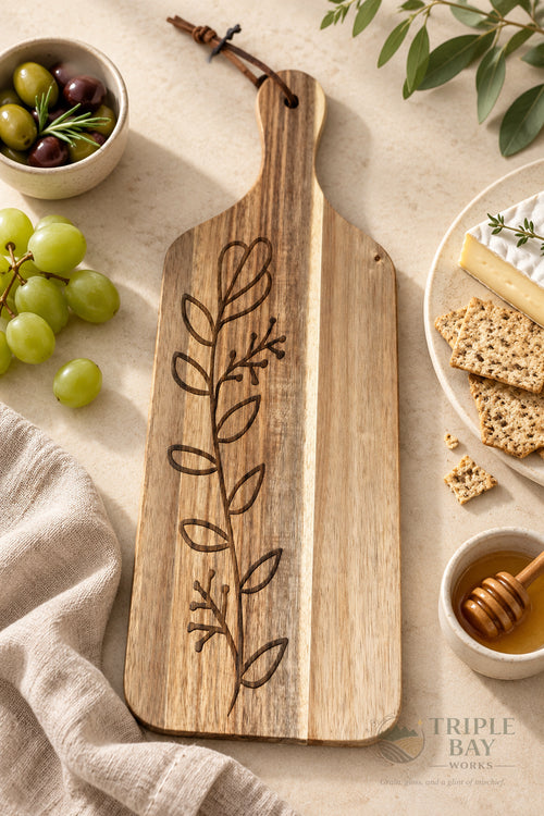 Botanical acacia serving board styled with cheese grapes crackers and olives