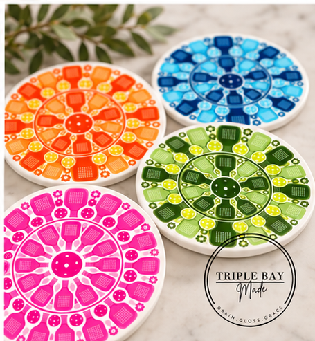 Four colorful pickleball mandala round ceramic coasters styled together by Triple Bay Made