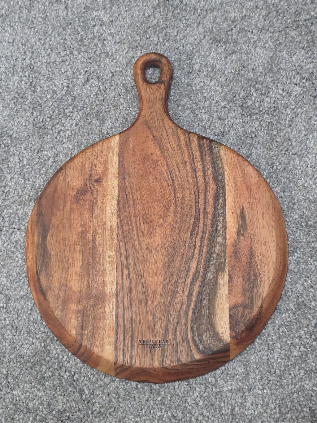 Round acacia paddle board engraved with nested cow, pig and chicken silhouettes