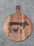 Reverse of round acacia board showing warm grain bands, oval hanging hole and Triple Bay Made maker mark