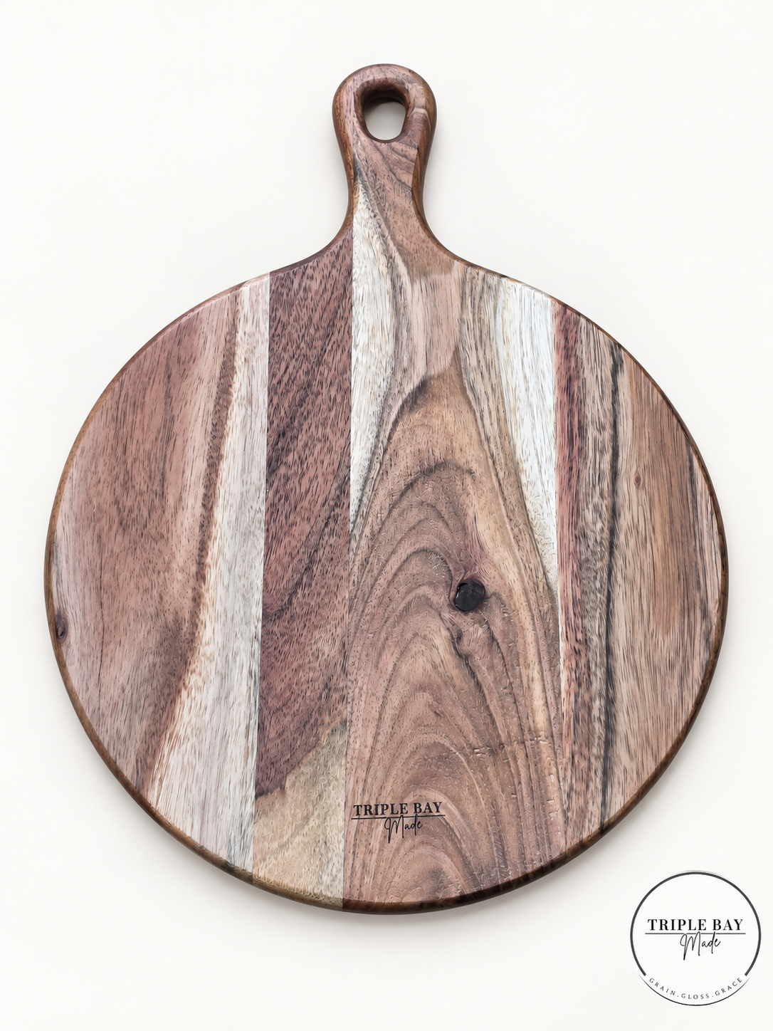 Reverse of round acacia paddle board showing contrasting wood grain, natural knot and Triple Bay Made maker mark
