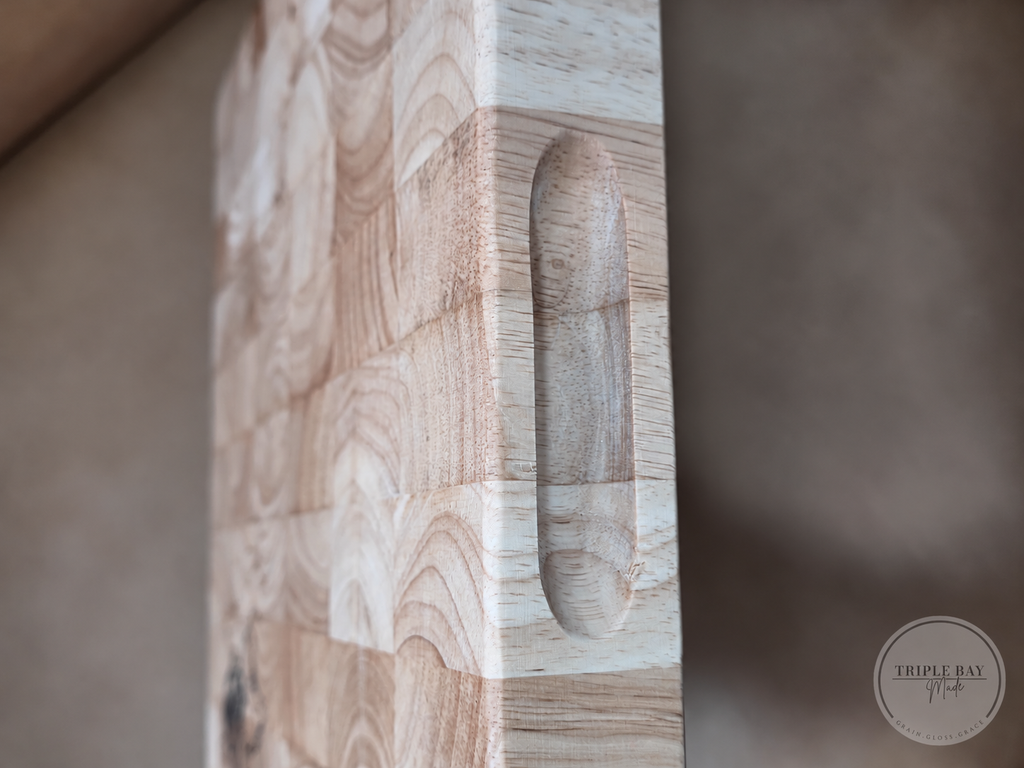 Close side view of the thick wood cutting board and its recessed grip
