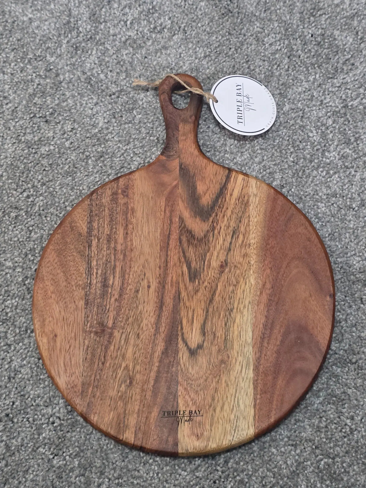 Reverse of Meadow Edge acacia board showing natural grain, handle and Triple Bay Made maker mark