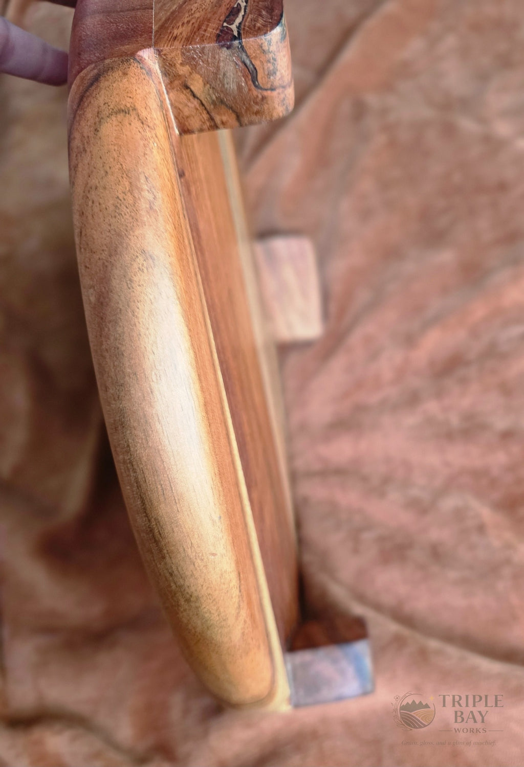 Close detail of one of three short acacia legs on the elevated serving board