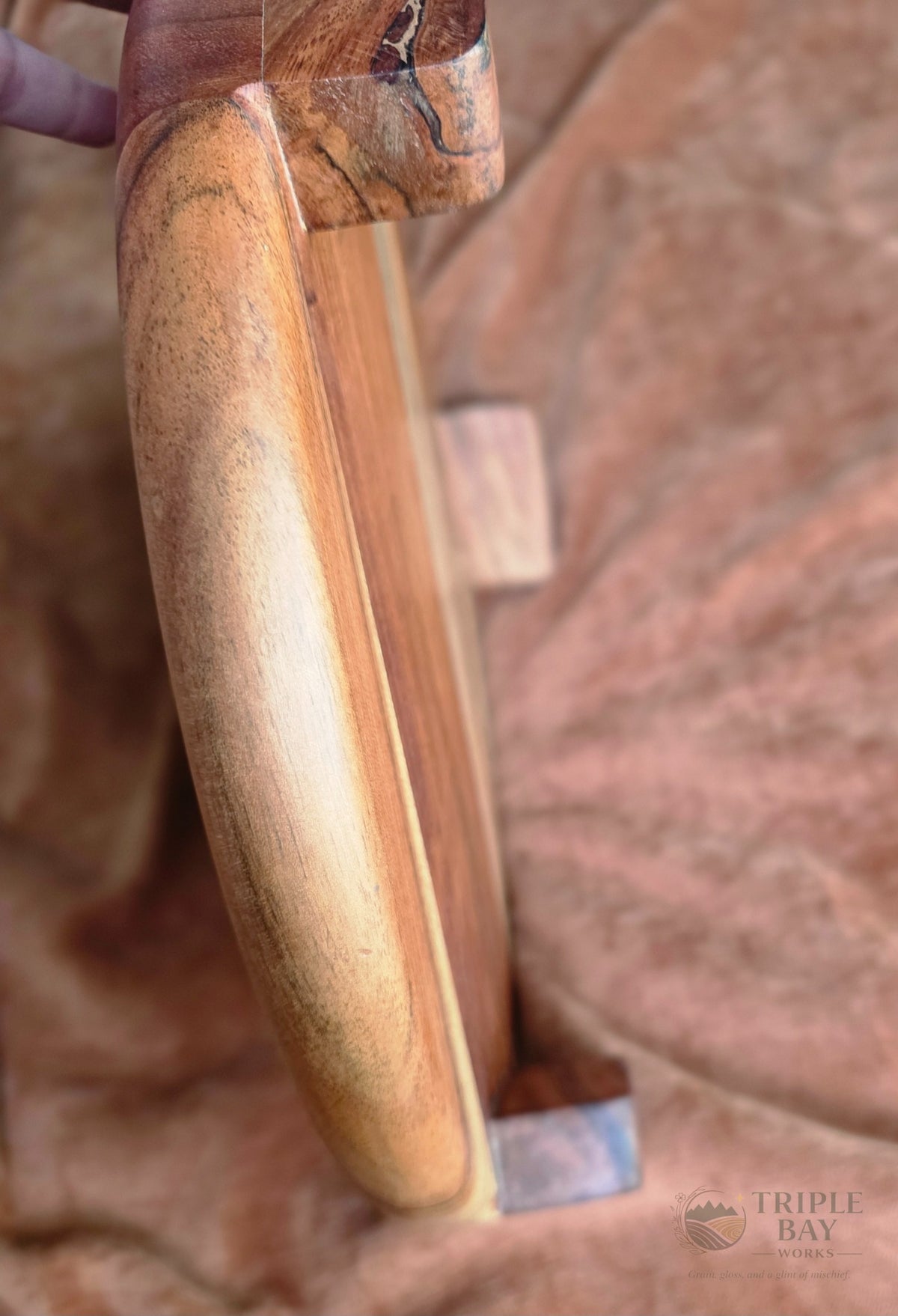 Close detail of one of three short acacia legs on the elevated serving board