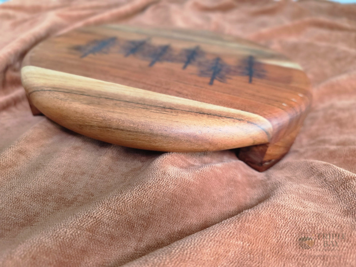 Side view showing the rounded edge and elevated legs of the acacia serving board