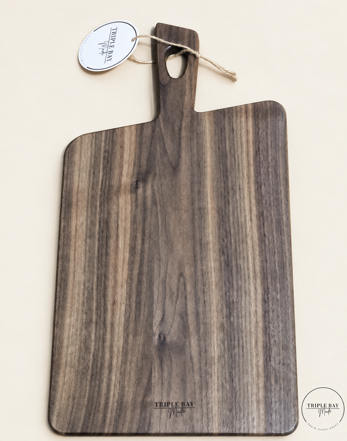 Plain reverse of walnut-finish acacia paddle board with handle and Triple Bay Made maker mark