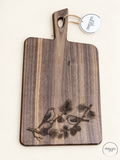 Acacia paddle board with walnut finish and two birds engraved on a pine branch