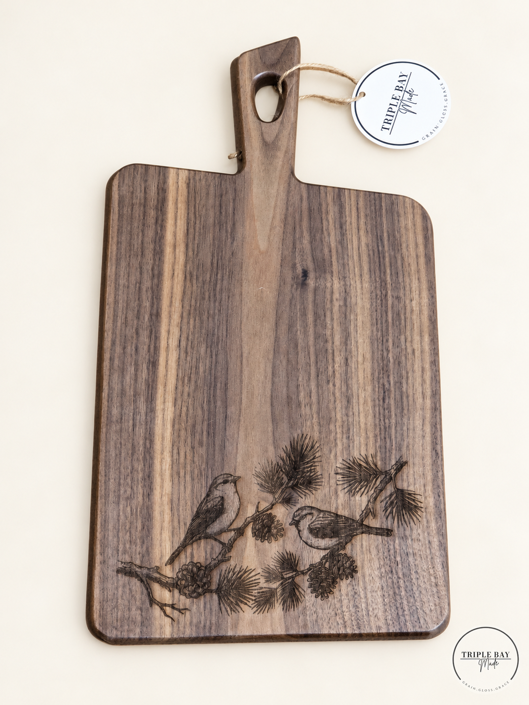 Acacia paddle board with walnut finish and two birds engraved on a pine branch
