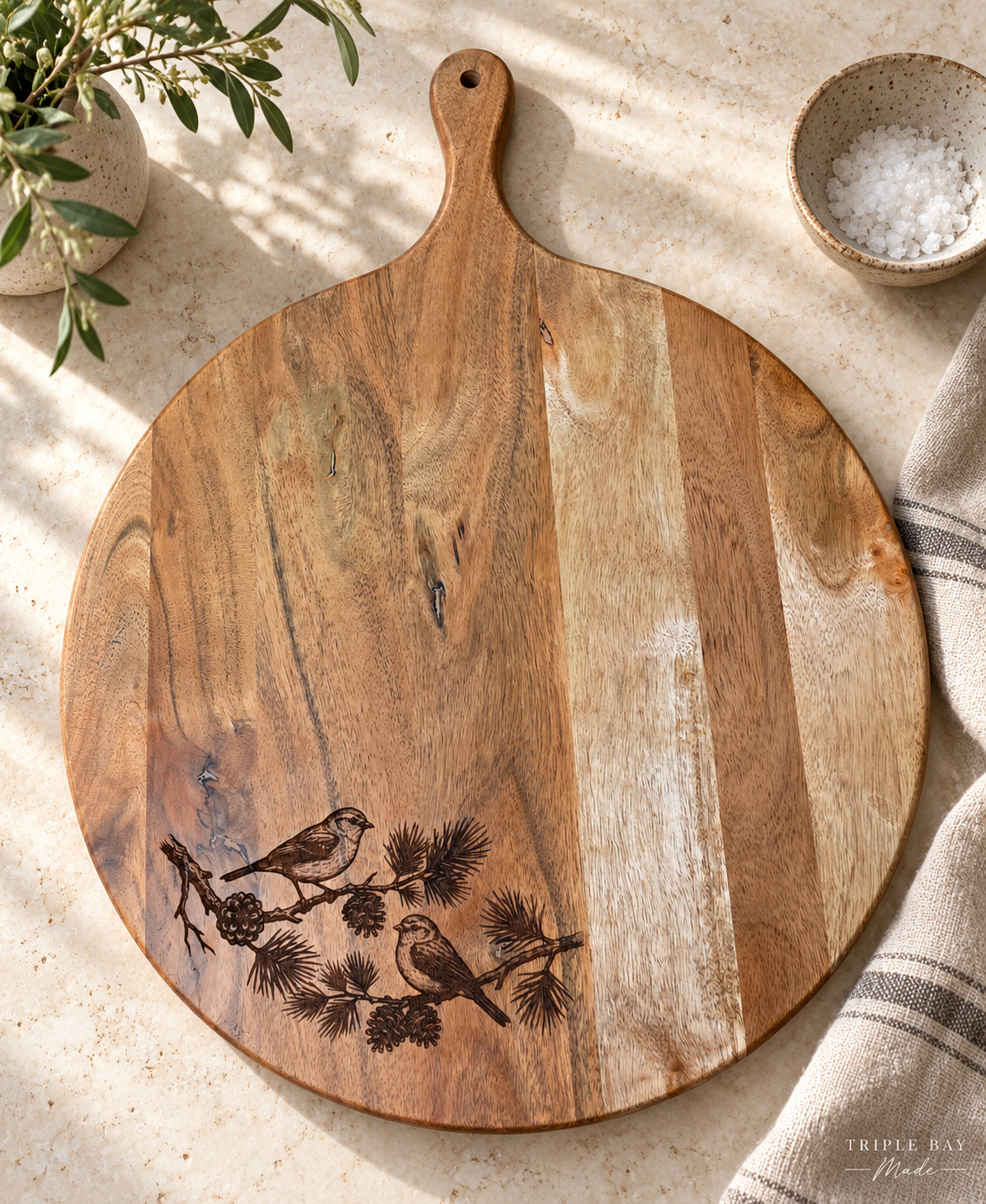 Pine & Song engraved acacia board styled on a light stone counter