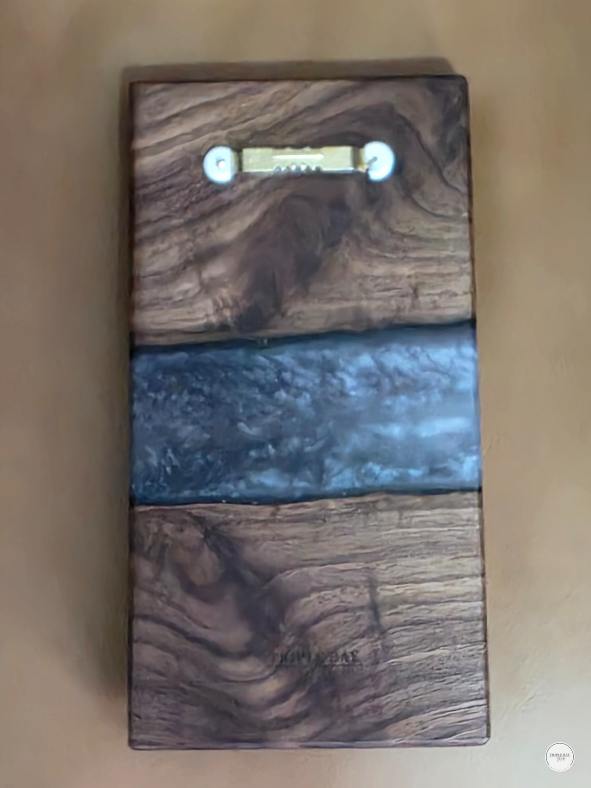 Back of walnut and resin propagation wall art showing attached sawtooth hanger