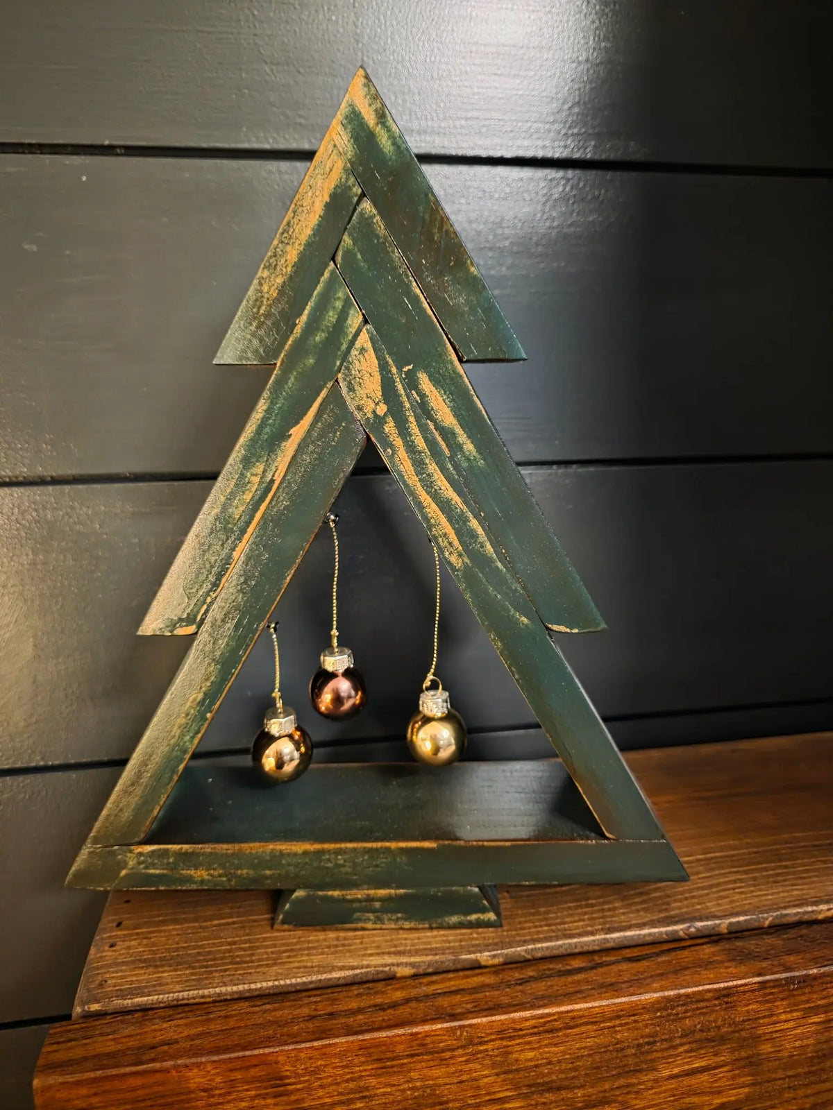 Distressed green stained pine Christmas tree with three hanging ornaments