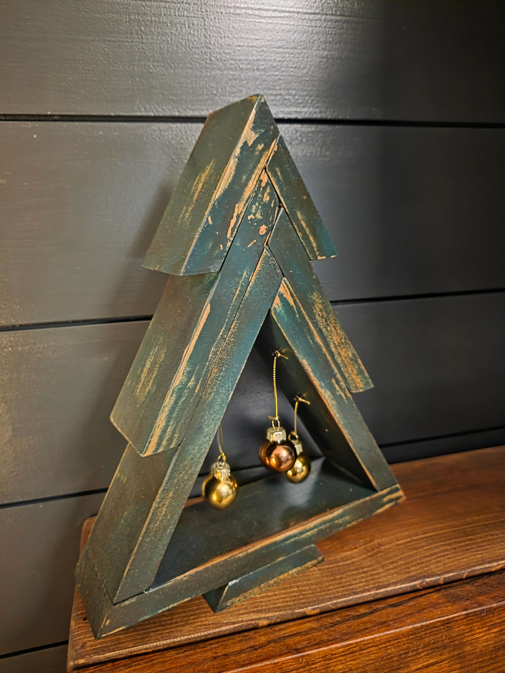 Distressed green stained pine Christmas tree with three hanging ornaments