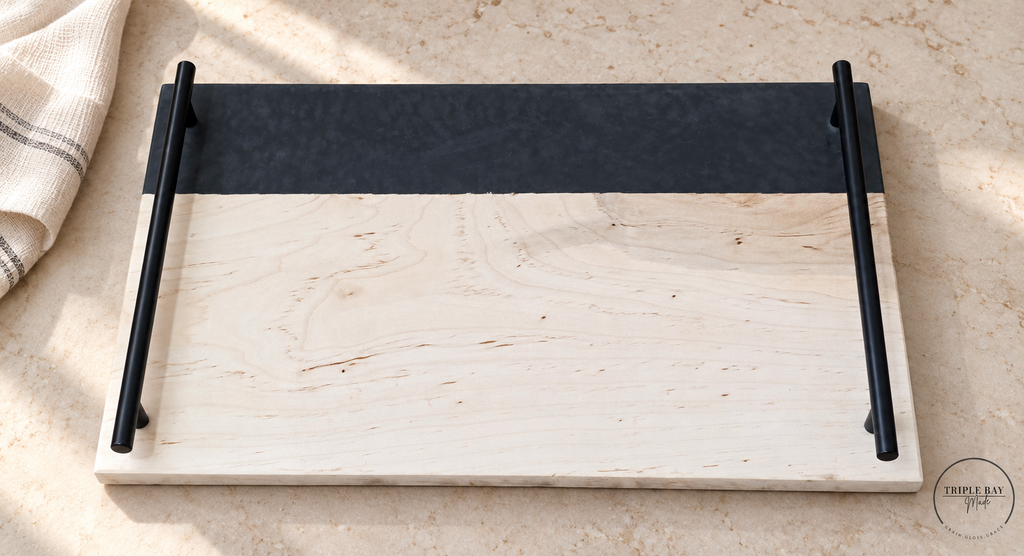Maple and charcoal resin serving tray with black handles on pale stone beside linen