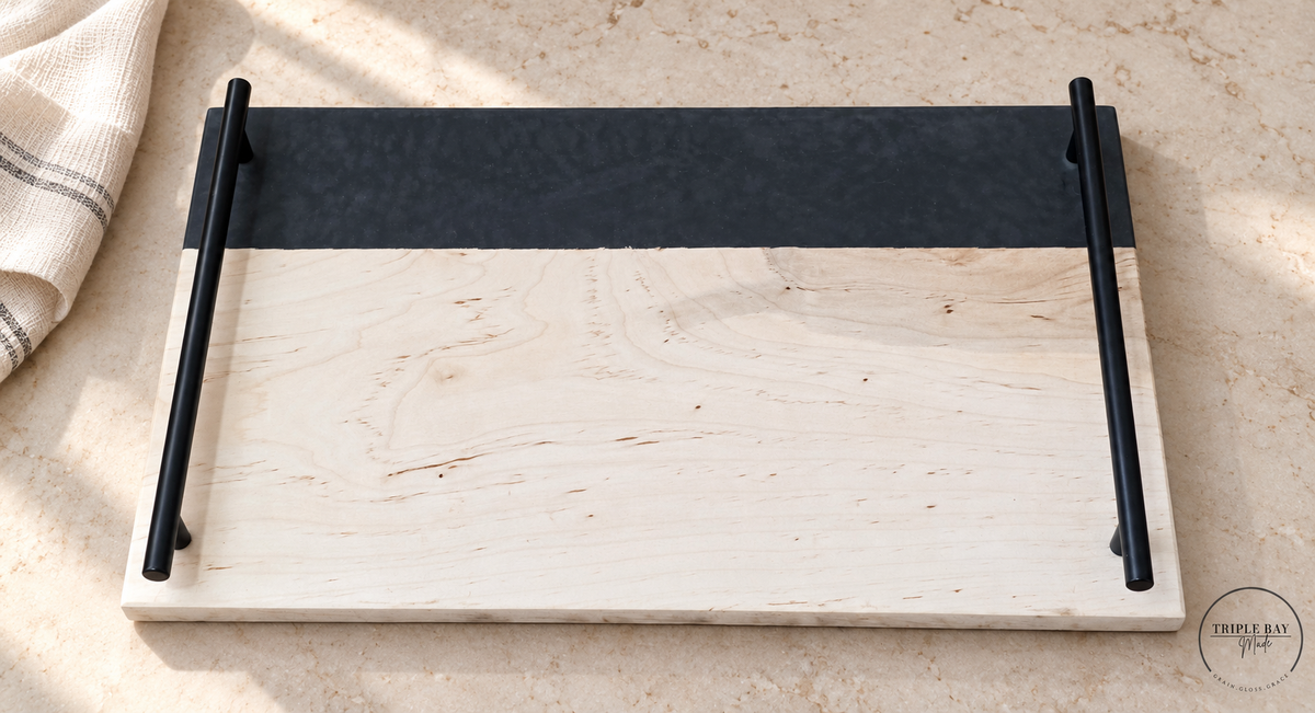 Maple and charcoal resin serving tray with black handles on pale stone beside linen