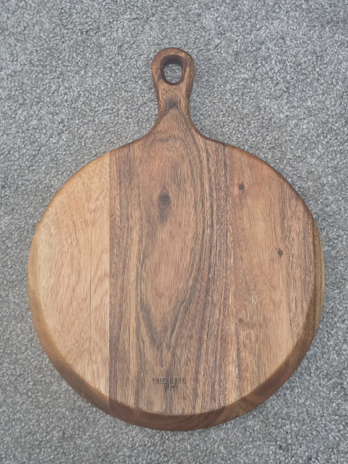 Unengraved reverse of acacia paddle serving board showing wood grain and Triple Bay Made maker mark